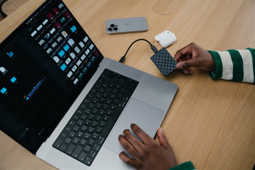 Osoba pracujúca na notebooku so súbormi uloženými na SSD Verbatim Store 'n' Go Mini Diamond