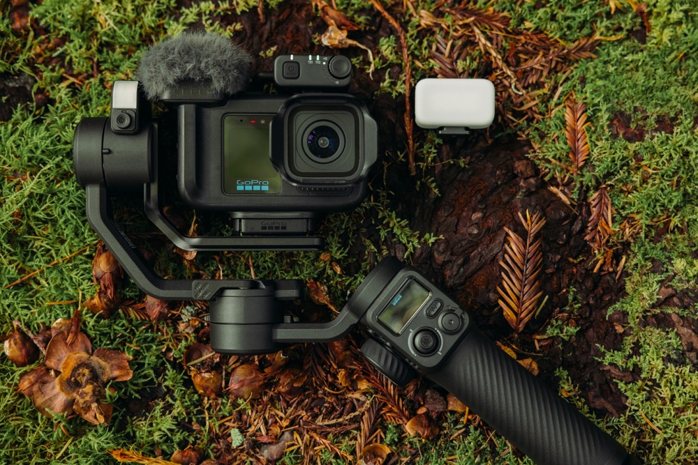 Outdoorová kamera GoPro MISSION 1 PRO Ultimate Creator Edition čierna GoPro MISSION 1 PRO so stabilizátorom, mikrofónom a svetlom položená na machom porastenom kmeni