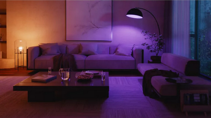 Inteligentná žiarovka Philips Hue Bluetooth, E27, 810 lm, White and Color Ambiance (4 ks) + Senzor Philips Hue pohybový Obývacia izba osvetlená farebným svetlom.