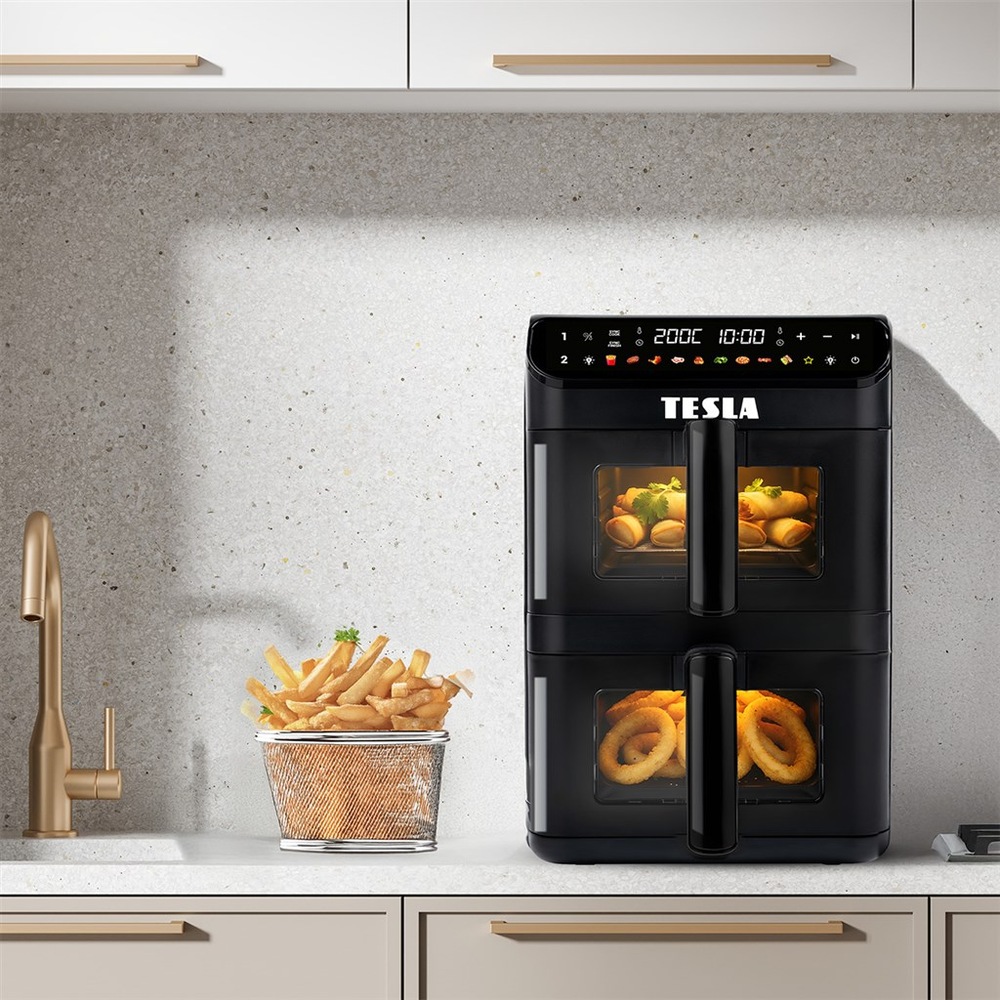 Teplovzdušná fritéza Tesla AirCook DualZone Q670 XXL stojí na kuchynskej linke, vedľa nej stojí košík s hranolkami.