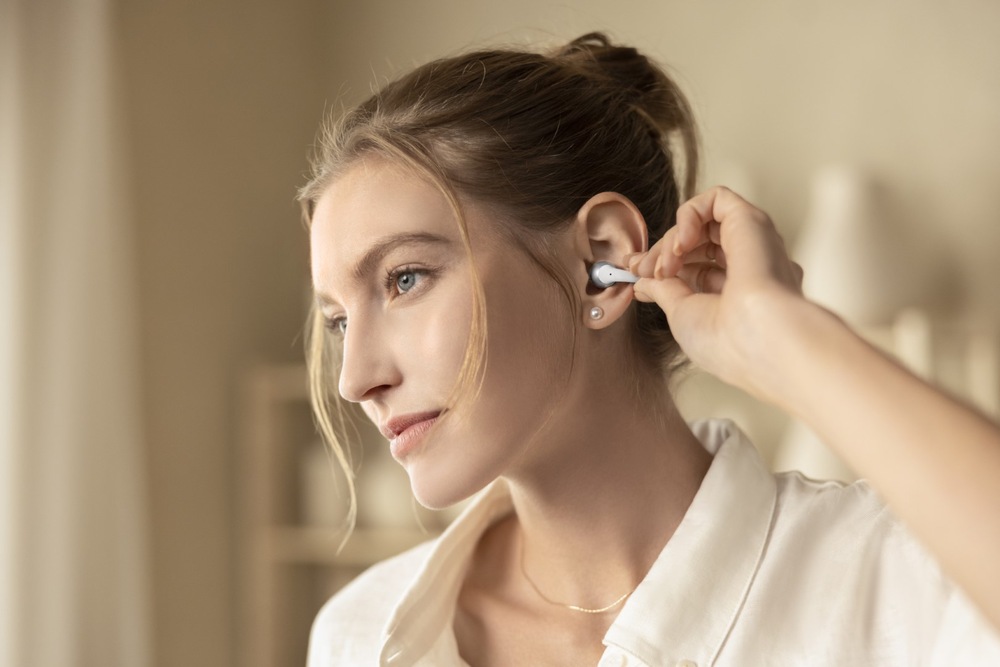 Slúchadlá Shokz OpenDots 2, Bluetooth čierna Žena sa dotýka slúchadiel s ľahkým dotykovým ovládaním
